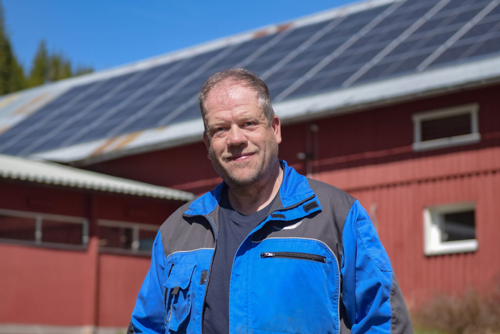 Jon Roger Neslund foran solcelleanlegg montert av solenergi norge